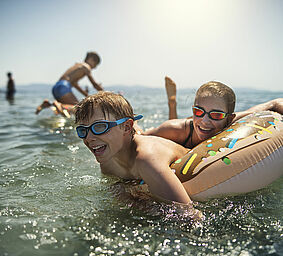 Kids having super fun in the sea waves